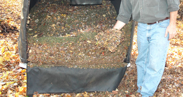 a man's hand showing the mulched leaves and grass collected.