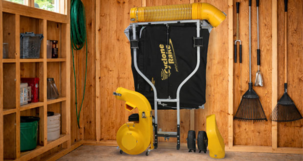 The Cyclone Rake hanging on a wall in a garage.
