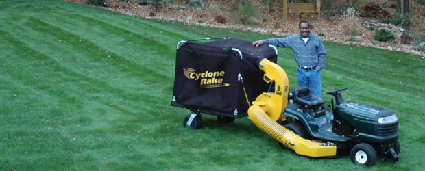 man standing aside a cyclone rake after clearing his lawn