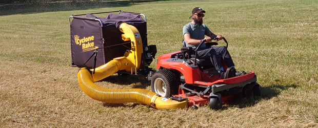 man pulling a Cyclone Rake Single with a zero-turn mower